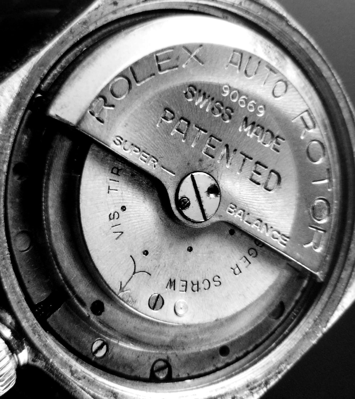 A Rolex automatic rotor from the 1930s, a single half-moon weight on a central pivot, stamped Rolex Auto Rotor Patented